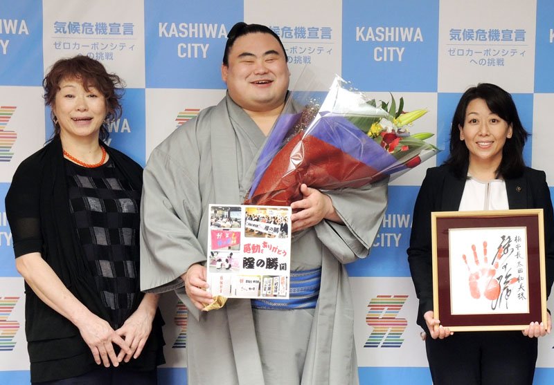 柏市役所を訪れ、花束を手にする隆の勝関。母親の石井雅代さん（左）と隆の勝関の手形を持つ太田市長の間で、満面の笑みを見せた＝２６日