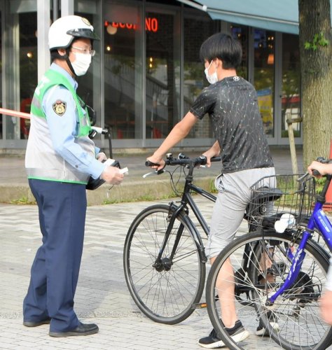 自転車の一斉取り締まりにあたる千葉西署員（左）＝２０日、千葉市美浜区
