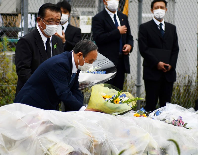 児童５人が死傷した事故で、事故現場を訪れ花を手向ける菅義偉首相（当時）＝昨年７月、八街市