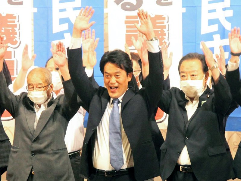 ３選を決め、万歳三唱する小西氏（中央）＝１０日、千葉市中央区