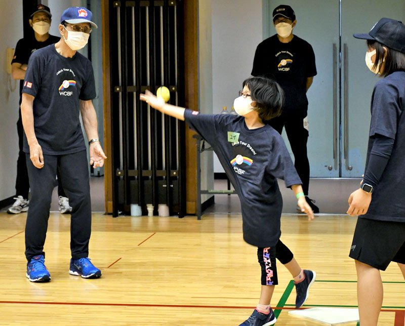王さん（左）の指導を受けながらボールを打つ練習をする少女（中央）＝３０日、成田市