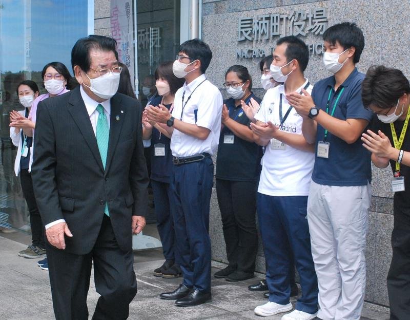 職員に拍手で見送られ町役場を後にする清田氏＝１２日、長柄町役場
