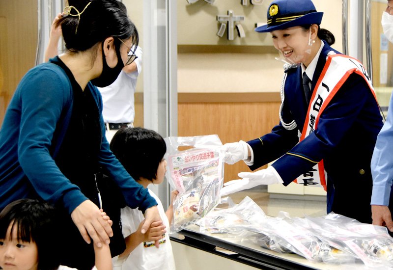 子どもに啓発グッズを手渡す一日署長の香山さん（右）＝１９日、千葉市稲毛区のイオン稲毛店
