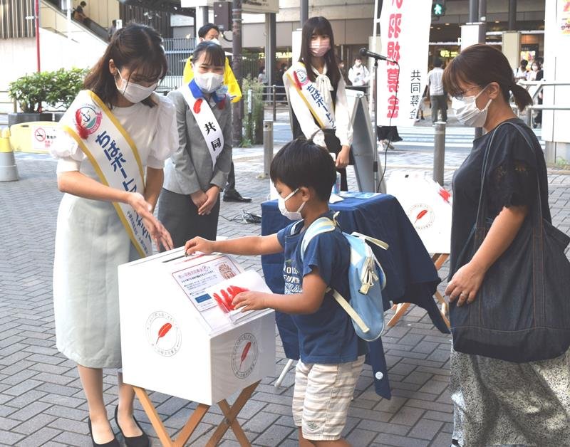 赤い羽根の街頭募金に応じる親子連れ＝１日、千葉市中央区
