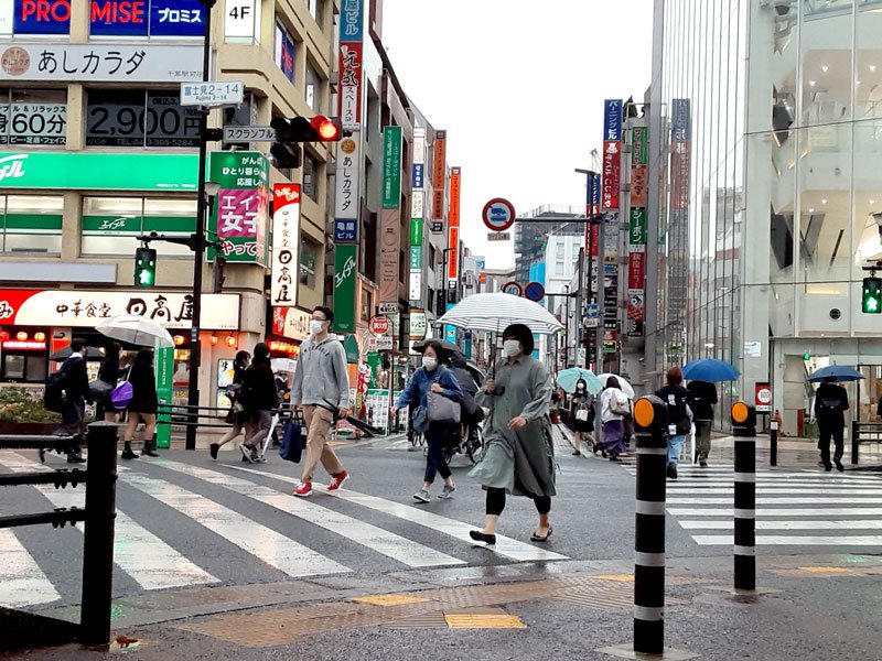 冷たい雨が降るなかコートなどを着込んで歩く人たち＝６日午後５時ごろ、千葉市中央区