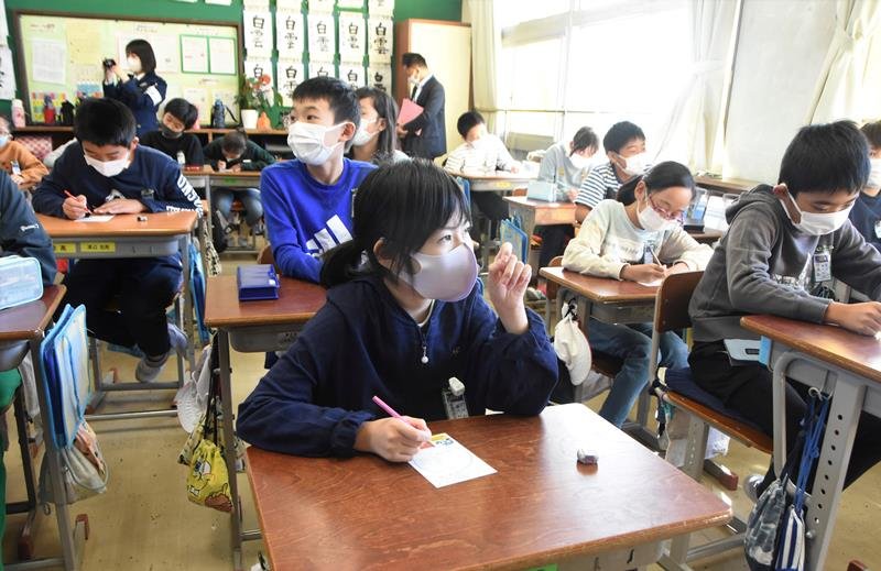 はがきに祖父母へのメッセージを書く児童たち＝千葉市中央区の市立登戸小学校
