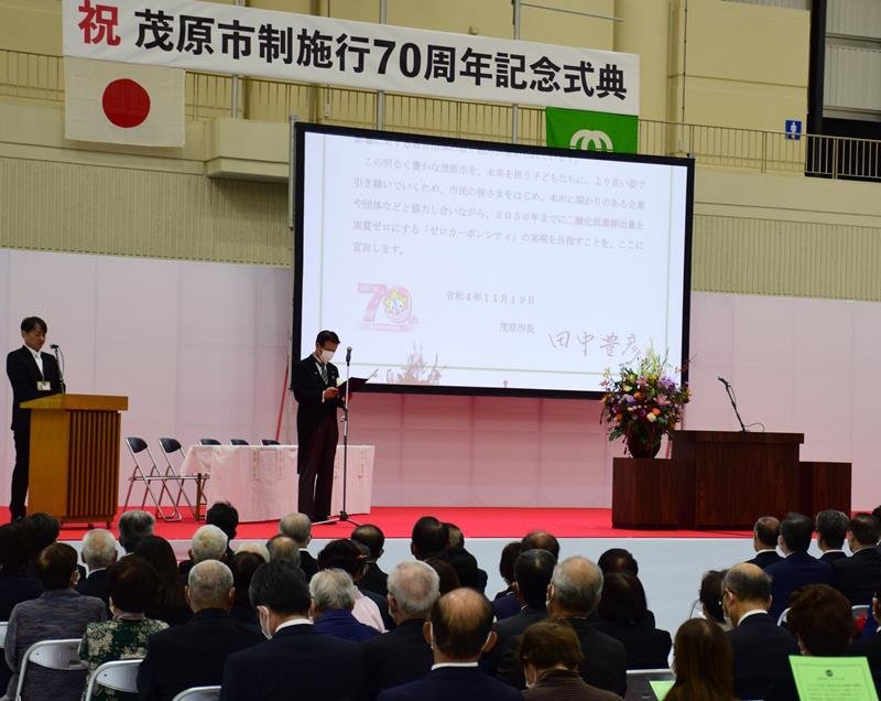 市制施行７０周年記念式典でゼロカーボンシティー宣言をする田中市長＝１９日、茂原市市民体育館
