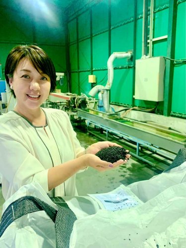 完成した再生ペレットを手にする吉田社長
