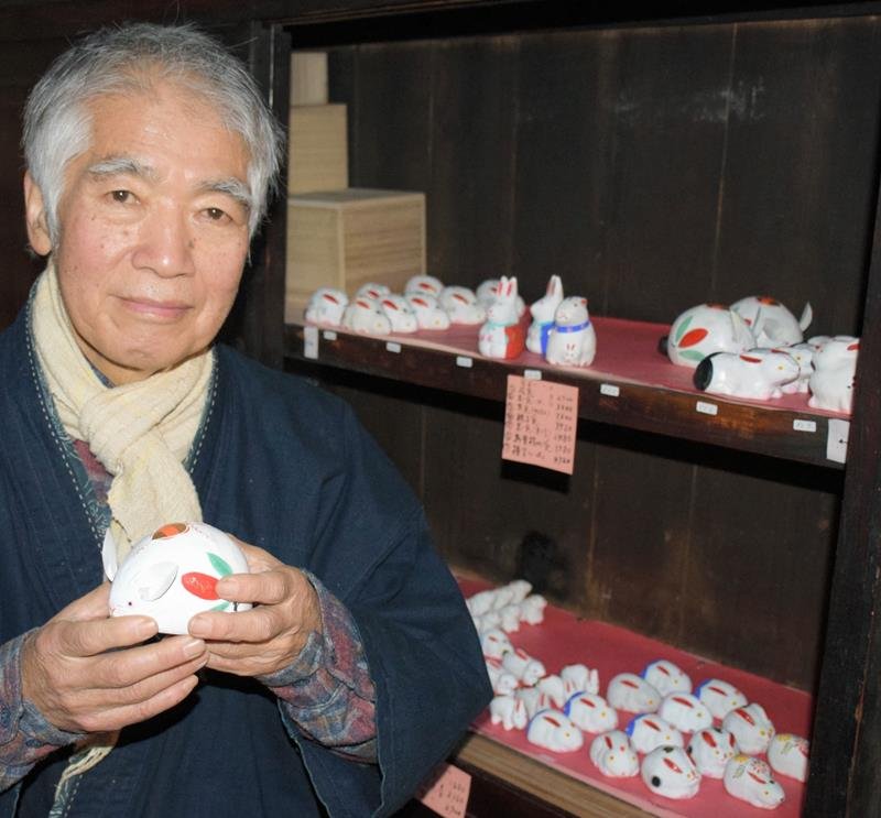 制作した兎を手にする千葉惣次さん。ぬくもりある作品が並ぶ＝１９日、長南町

