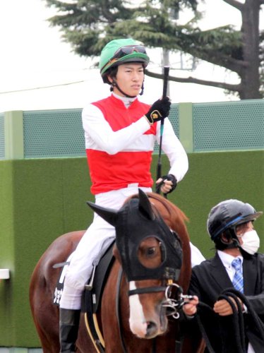 中山競馬場の花道でむちを握り締め、レースに向かう菅原騎手＝昨年１２月４日、船橋市
