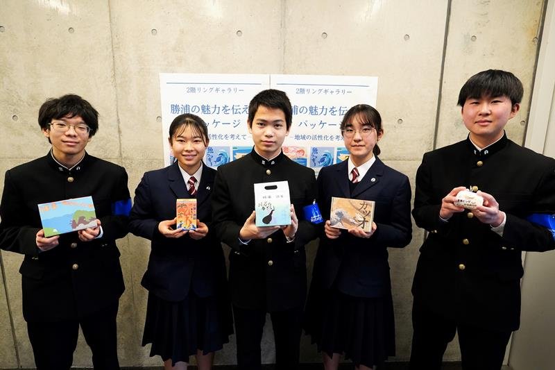 デザインした商品パッケージを持つ勝浦中３年生＝勝浦市のキュステ
