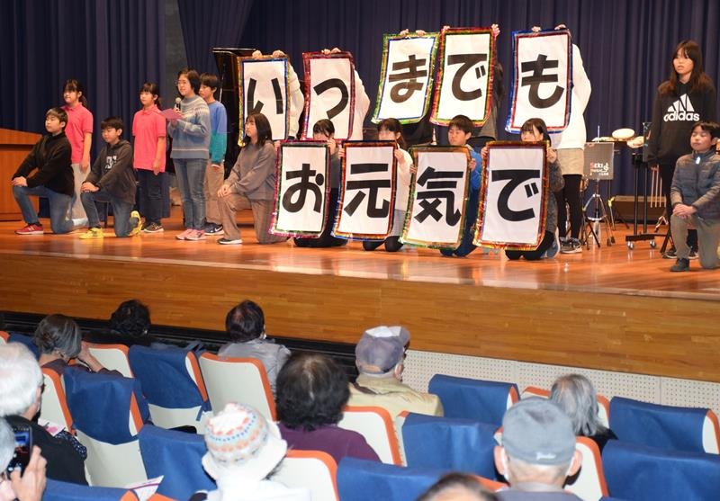 高齢者の前で元気な歌声を披露した児童たち＝白子町
