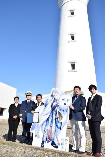 キャラクターのパネルと記念撮影に応じる越川信一市長（左から３番目）ら贈呈式出席者＝銚子市
