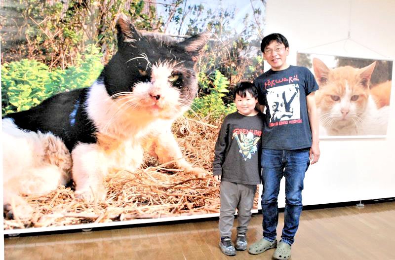 ４年ぶりの写真展を開催中の津乗さんと息子の登亀雄君＝船橋市