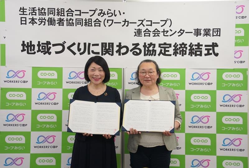 協定書を持つ新井理事長（左）と田中理事長＝東京都豊島区
