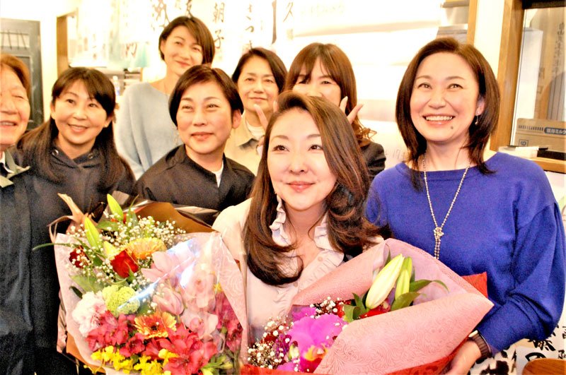 再選を決めて花束を受け取り、女性スタッフらと喜ぶ自民の鈴木氏＝９日午後１０時半ごろ、船橋市