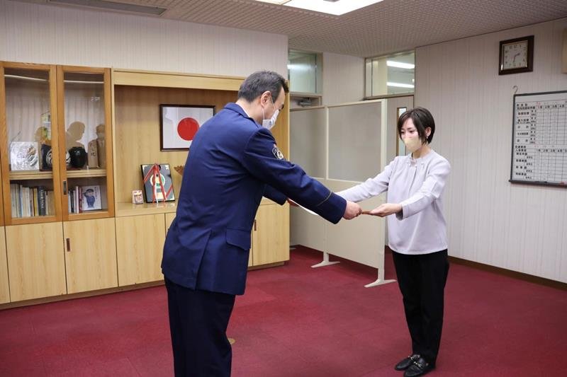 江波戸署長（左）から感謝状を受け取る佐久間さん＝千葉市緑区の千葉南署　