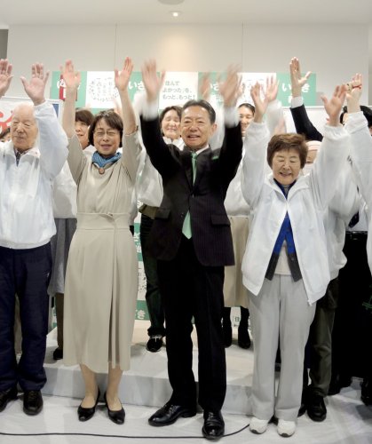 ６選を果たし支援者らと万歳して喜ぶ井崎氏＝２３日午後１１時ごろ、流山市