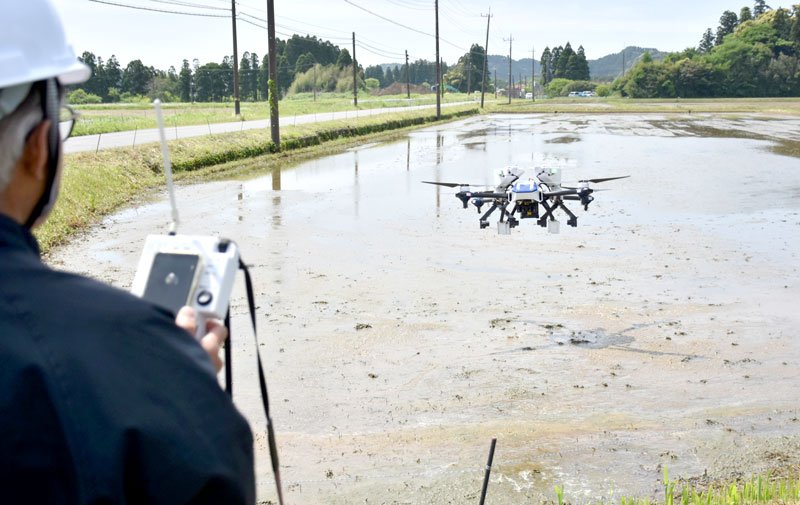 いすみ市の田んぼで行われたドローンによる種もみのじかまき＝１日、同市高谷