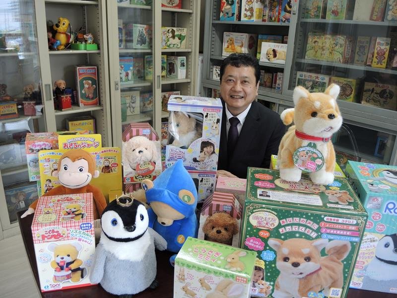 １００年間で商品化したおもちゃに囲まれる東山社長＝松戸市

