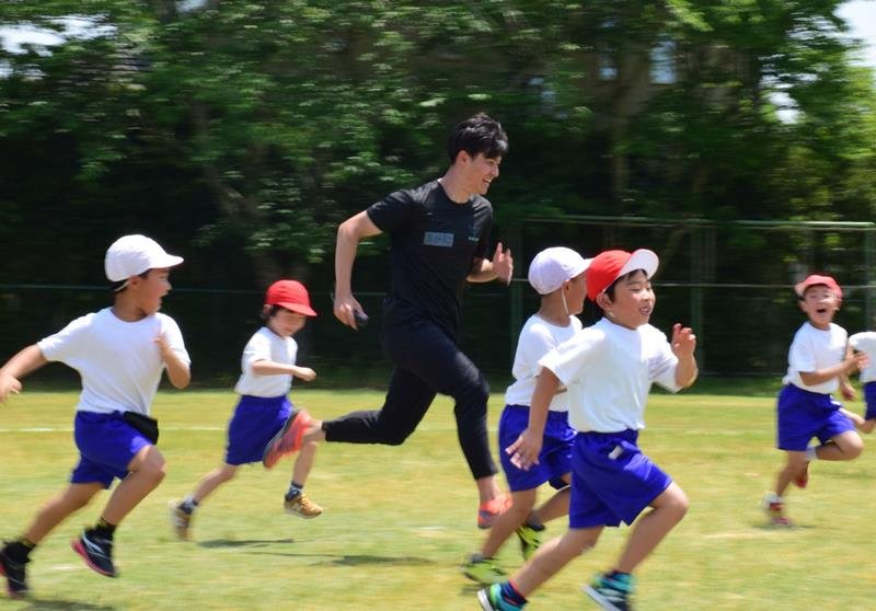 コーチと５０メートル競争を楽しむ子供たち＝白子町立関小
