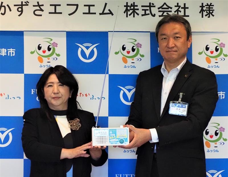 防災ラジオを寄贈する石村社長（左）と高橋市長＝富津市
