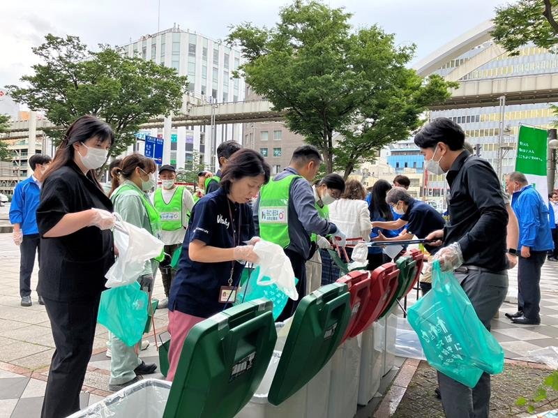特設したごみ箱に、拾ったペットボトルなどを分別して入れる参加者＝千葉市中央区
