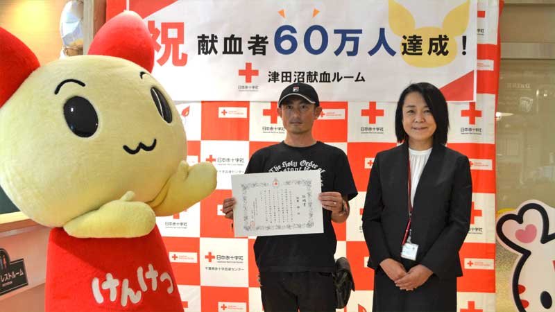 ６０万人目の献血者となった飯野さん（中央）＝２１日、船橋市の津田沼献血ルーム