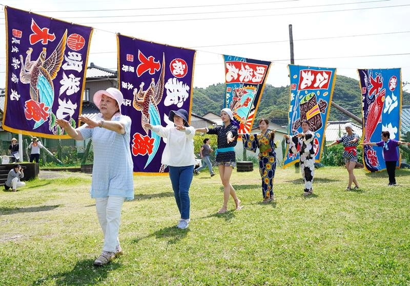 大漁旗がはためく中、房州御宿音頭を踊る参加者たち＝御宿町の旧岩和田小
