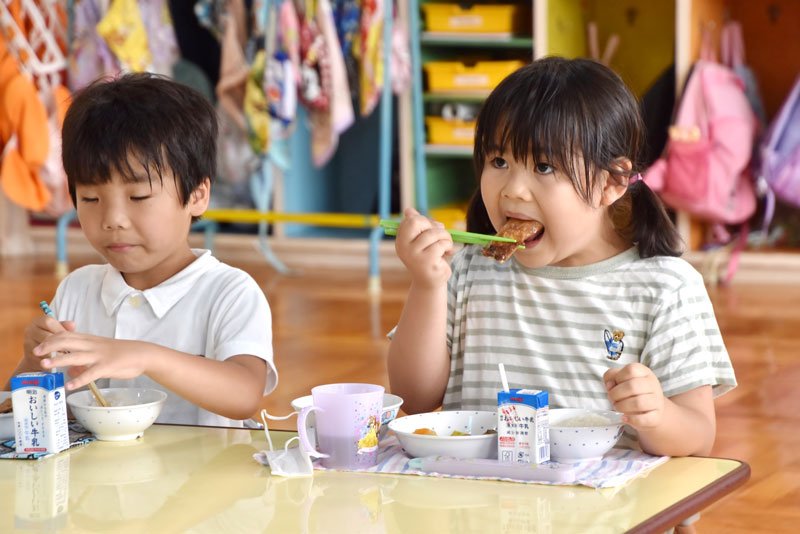 館山市近海で取れたブリ（ワカシ）の照り焼きを頬張る園児＝５日、館山市