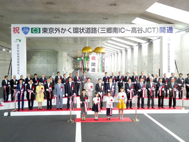 テープカットとくす玉開きで外環道の開通を祝う関係者＝２０１８年６月２日、市川市の外環道北千葉ＪＣＴ付近