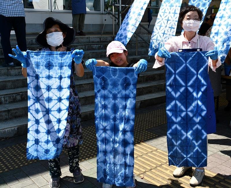鮮やかな藍色に染め上げた手ぬぐいを披露する参加者＝５日、神崎町
