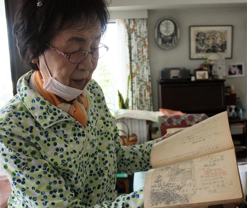 小学５年生の時に使っていた国史のノートを手にする伊東さん＝千葉市中央区
