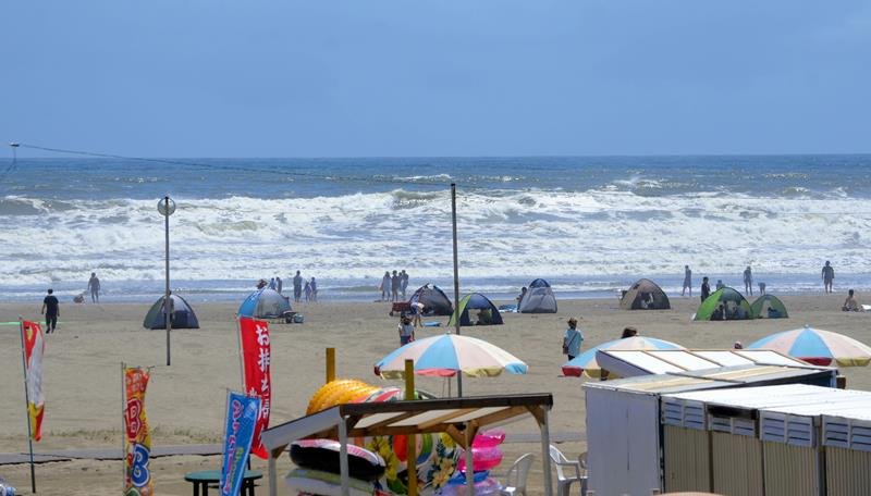 片貝海水浴場は波が高く「遊泳禁止」となり、観光客は砂浜で遊んだ＝１０日、九十九里町