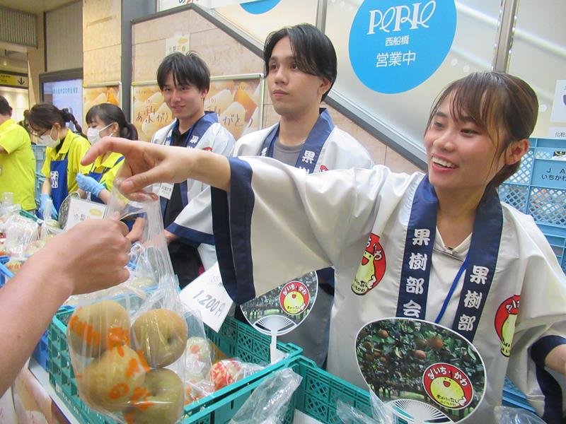 駅構内で「市川のなし」を売る明海大の学生ら＝１８日、ＪＲ西船橋駅
