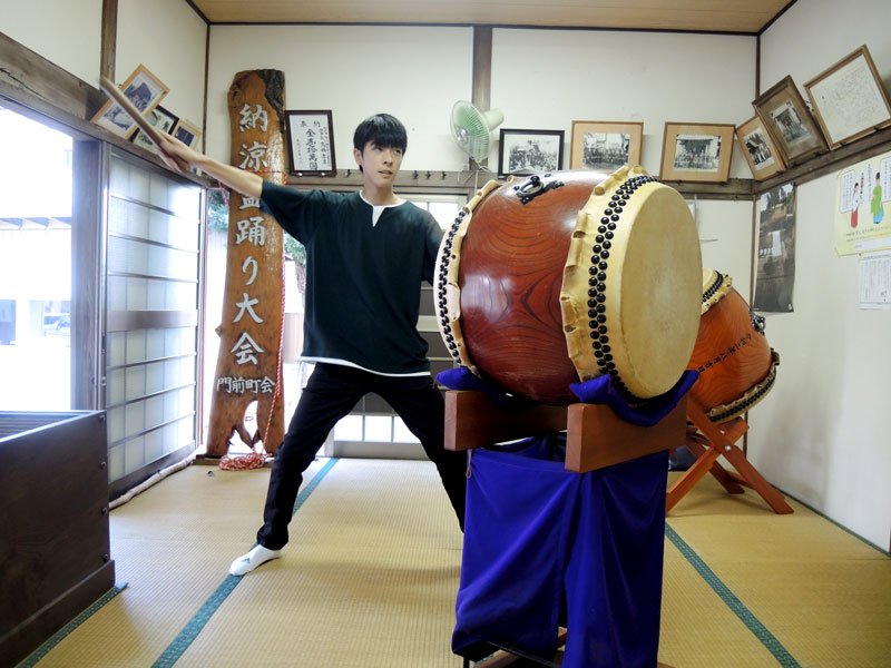 夏まつりを終え、門前八坂神社本殿で保管される御陣屋太鼓。まつりで演奏した片見さんがポーズを取った＝１６日、松戸市