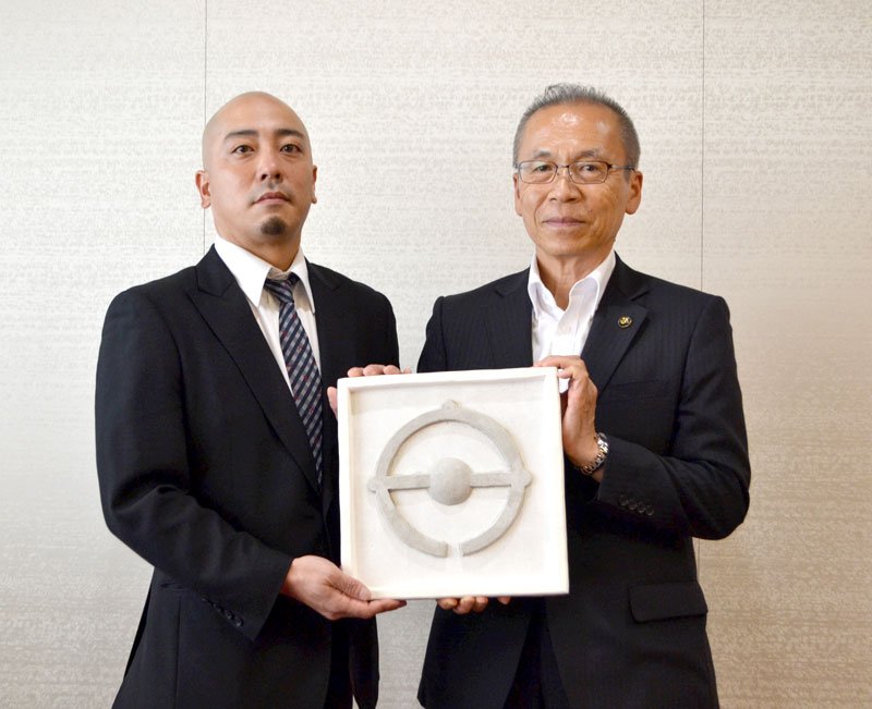 鏝絵を寄贈した小倉さん（左）＝船橋市役所