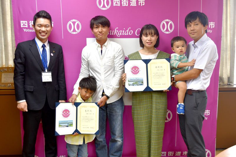 ＰＲ横断幕のキャッチコピーを考案した優斗ちゃん（中央左２人目）と下道さん（同右）＝四街道市役所