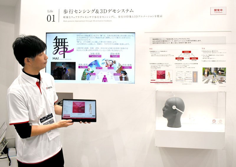 歩行時の姿勢を確認できる身体装着型のセンサーを紹介する京セラの担当者＝１６日、幕張メッセ
