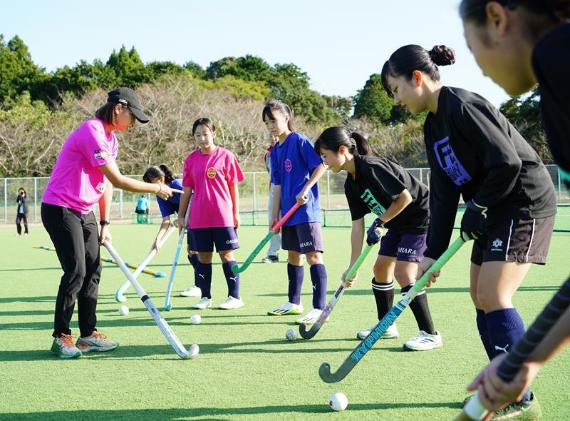 瀬川選手（左）からアドバイスを受ける大原中ホッケー部の女子部員たち＝いすみ市
