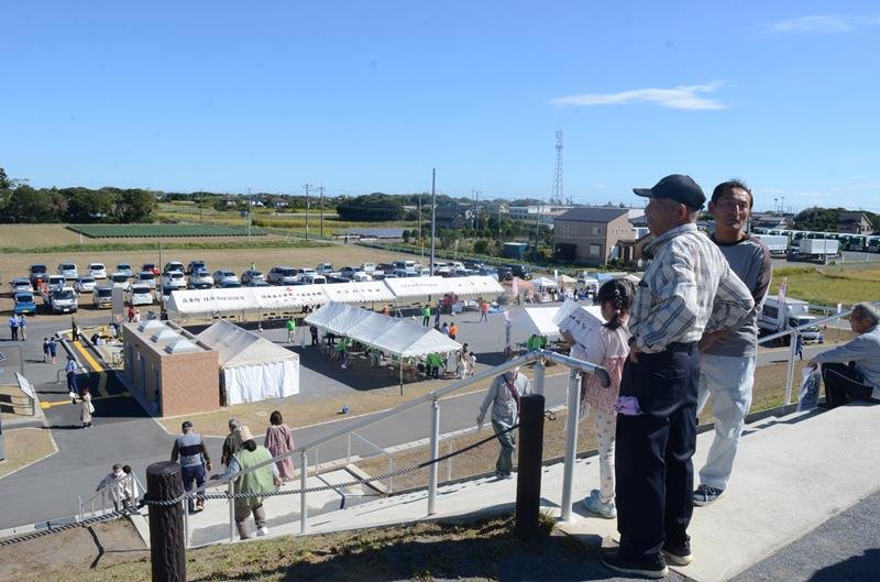 津波避難広場で開催された防災フェスタで、人工丘を登る地域住民ら＝２２日、山武市
