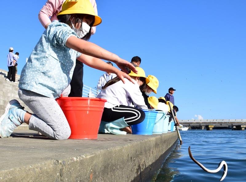 南白亀川にウナギを放流する子どもたち＝２４日、白子町
