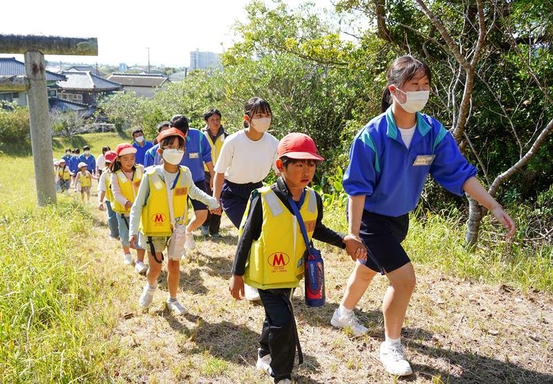 津波避難訓練で手をつなぎ高台へ向かう小中学生＝御宿町
