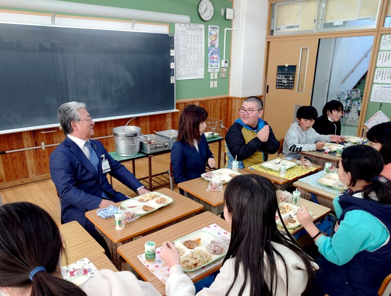 小出市長（左）と市制６０周年記念給食を味わう児童ら＝市原市の千種小学校