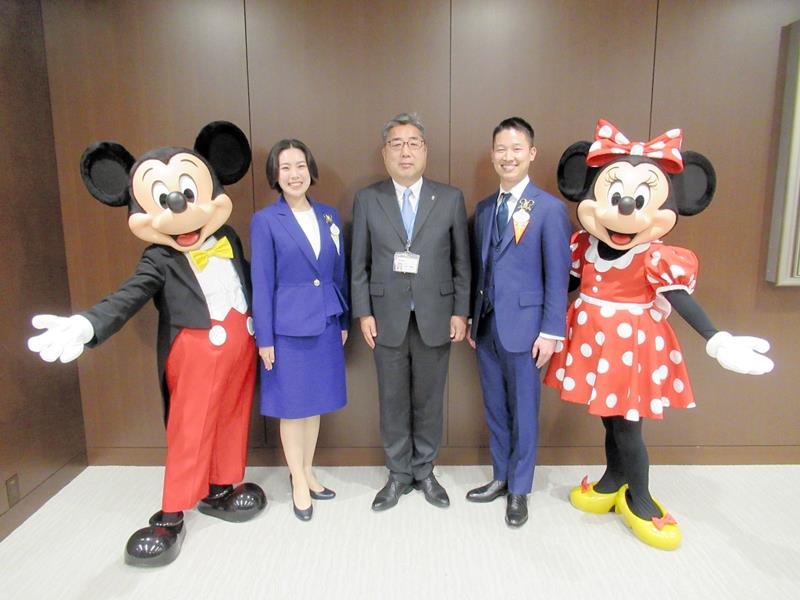 ミッキー、ミニー、内田市長（中央）と記念撮影に臨む新アンバサダーの柴田さん（右から２人目）と味方さん（左から２人目）＝浦安市役所
