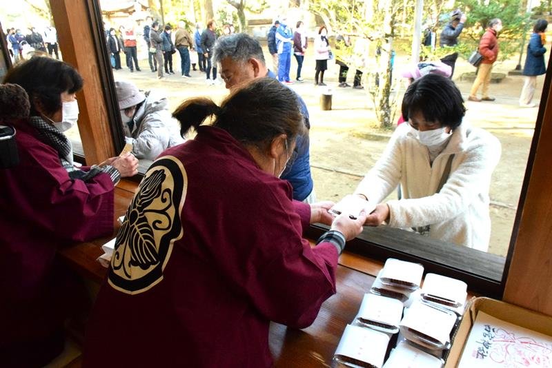 「とがらしごぼう」を受け取る参拝者ら＝１８日、旭市