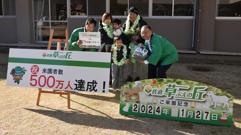 佐倉草ぶえの丘の来園者数５００万人達成を記念し、西田市長（右）と田辺園長（左）から祝福を受ける網野さん家族＝２７日、佐倉市飯野
