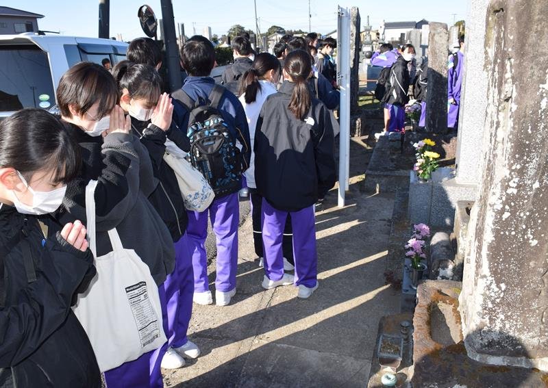 元禄地震の供養碑に手を合わせ、教訓を胸に刻む長生中防災部の部員ら＝３日、長生村の本興寺
