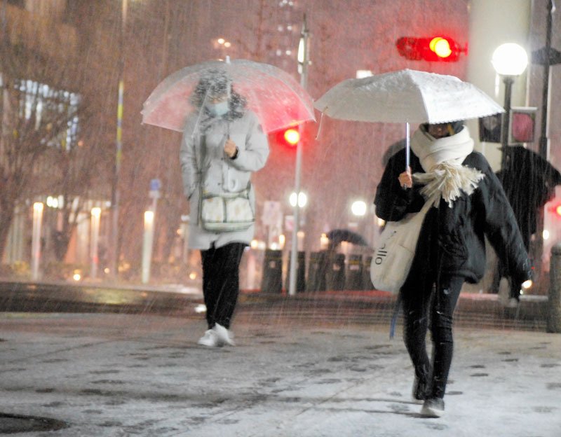 雪の中、駅に向かう人たち＝５日午後５時４５分ごろ、千葉市中央区