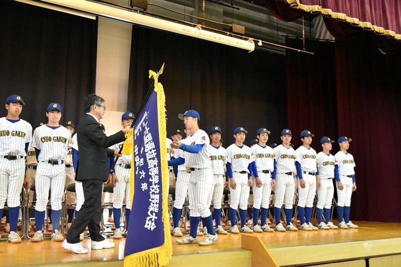 横田校長（左）から選抜旗を受け取る中村主将＝１７日、我孫子市の中央学院高校
